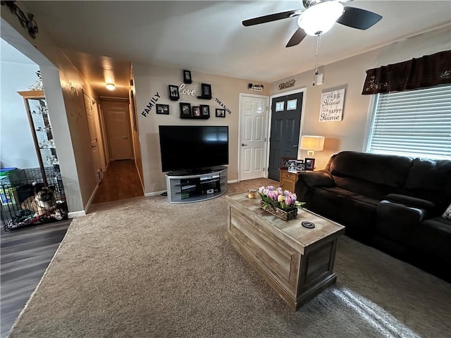 living area with a ceiling fan and baseboards