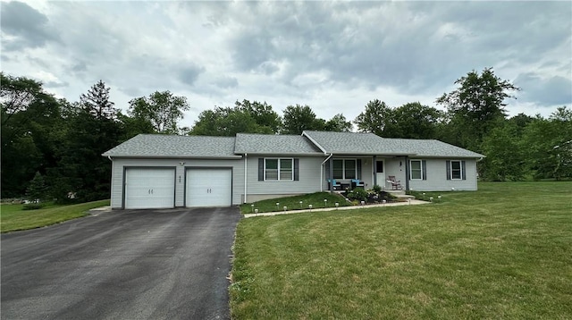 single story home featuring a garage, a porch, driveway, and a front lawn