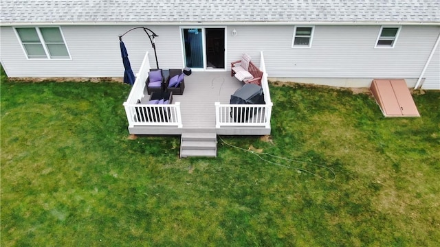 rear view of house with a wooden deck, roof with shingles, a lawn, and an outdoor living space