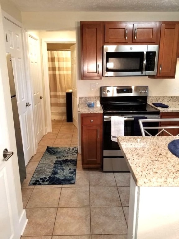 2807 Middle Rd, Hampton, PA 15116 - kitchen with stainless steel appliances, light tile patterned floors, and brown cabinetry