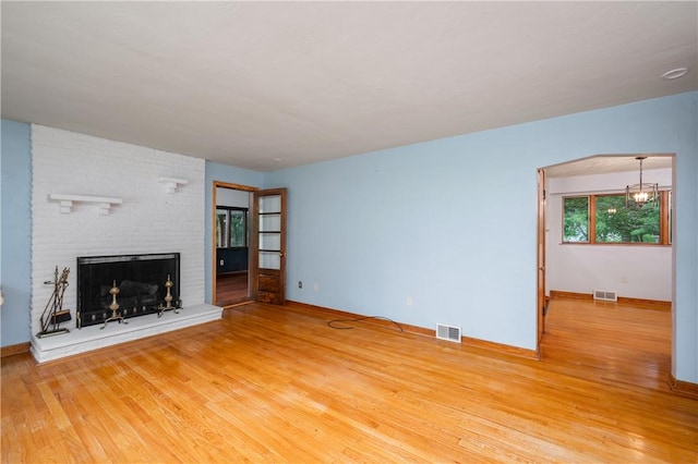 1833 Allison Ave, Mccandless, PA 15101 - unfurnished living room with wood finished floors, a fireplace, and a chandelier