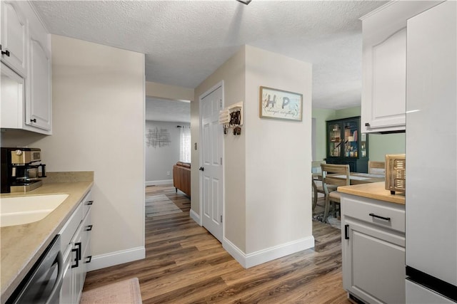 3118 Ridge Rd, South Park, PA 15129 - kitchen with dishwasher, light wood-style floors, white cabinetry, light countertops, and a textured ceiling