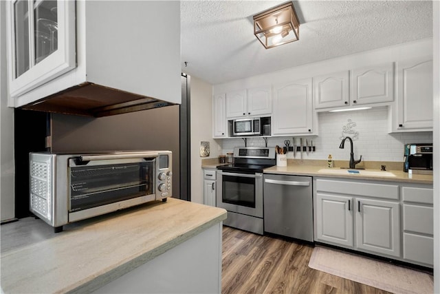 3118 Ridge Rd, South Park, PA 15129 - kitchen featuring stainless steel appliances, white cabinets, light countertops, light wood-type flooring, and a textured ceiling