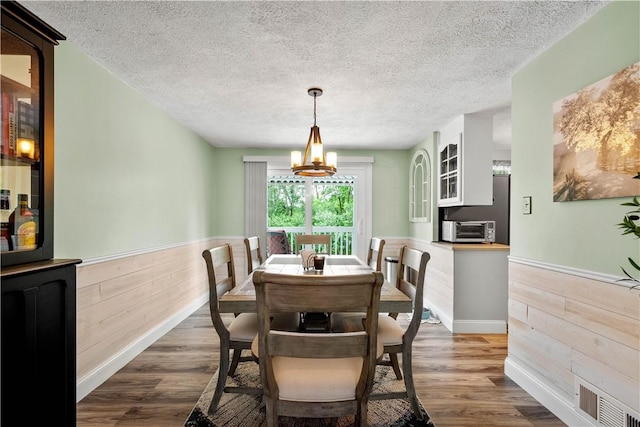 3118 Ridge Rd, South Park, PA 15129 - dining area featuring wainscoting, wooden walls, a chandelier, a textured ceiling, and dark wood-style floors