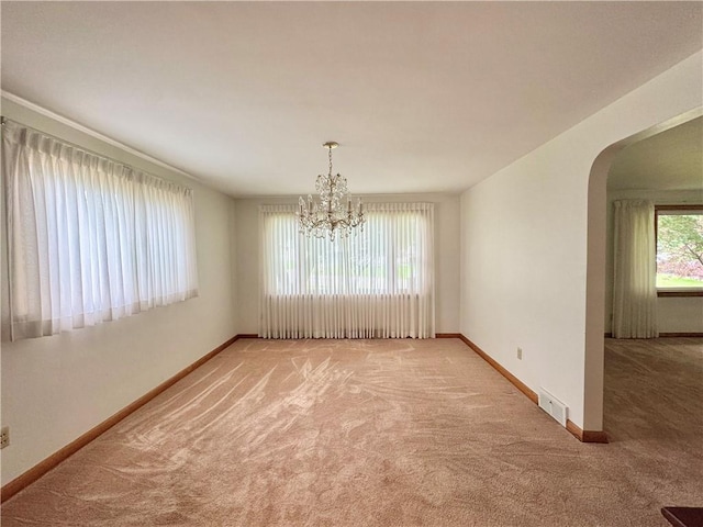7 E Sheridan Ave, New Castle/1St, PA 16105 - spare room featuring light colored carpet, arched walkways, and a chandelier