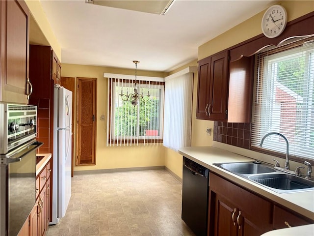 7 E Sheridan Ave, New Castle/1St, PA 16105 - kitchen with black dishwasher, stainless steel oven, freestanding refrigerator, decorative light fixtures, and light countertops