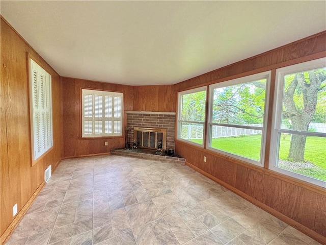 7 E Sheridan Ave, New Castle/1St, PA 16105 - unfurnished living room with wooden walls, a brick fireplace, and stone finish floors