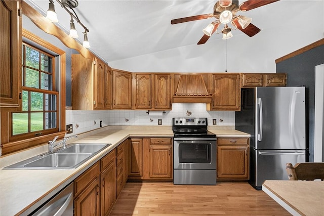 228 Bowman Rd, South Fayette, PA 15017 - kitchen with stainless steel appliances, custom range hood, vaulted ceiling, brown cabinetry, and ceiling fan