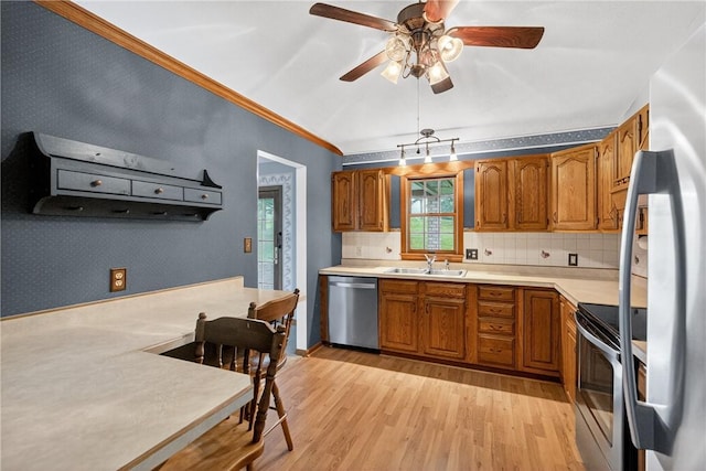 228 Bowman Rd, South Fayette, PA 15017 - kitchen with stainless steel appliances, brown cabinetry, light wood-style floors, and crown molding