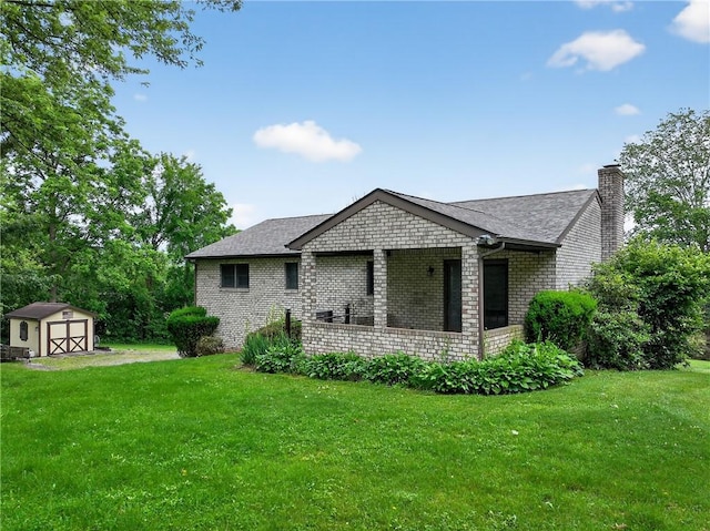 228 Bowman Rd, South Fayette, PA 15017 - view of home's exterior with a storage unit, a yard, a chimney, and brick siding