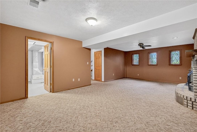 228 Bowman Rd, South Fayette, PA 15017 - unfurnished living room featuring light colored carpet, a textured ceiling, a ceiling fan, and a brick fireplace