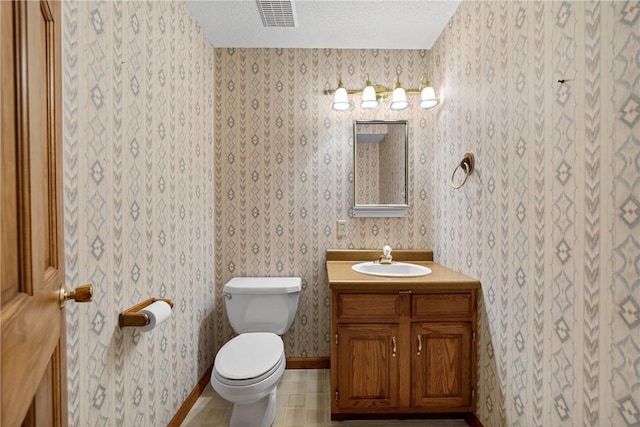 228 Bowman Rd, South Fayette, PA 15017 - half bathroom featuring wallpapered walls, vanity, a textured ceiling, and tile patterned floors