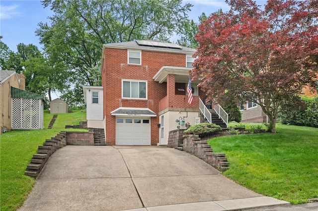 4457 Woodhill Dr, Munhall, PA 15120 - view of front of house featuring stairway, an attached garage, concrete driveway, solar panels, and a front yard