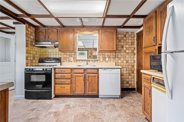 4457 Woodhill Dr, Munhall, PA 15120 - kitchen featuring white appliances, under cabinet range hood, light countertops, coffered ceiling, and decorative backsplash