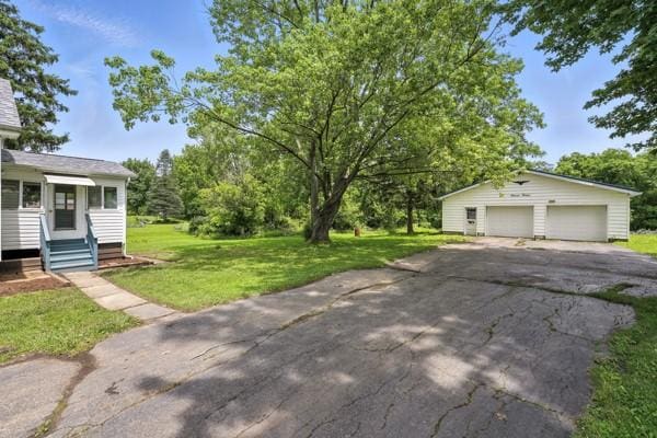 1112 Grigsby, Shenango Twp Law, PA 16101 - view of green lawn featuring entry steps, a detached garage, and an outbuilding