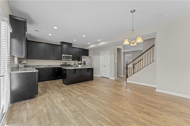 2804 Pointe View Dr, Adams Twp, PA 16046 - kitchen featuring appliances with stainless steel finishes, a chandelier, light countertops, dark cabinets, and a breakfast bar area