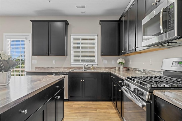 2804 Pointe View Dr, Adams Twp, PA 16046 - kitchen featuring appliances with stainless steel finishes, dark cabinets, light wood-type flooring, and light stone countertops