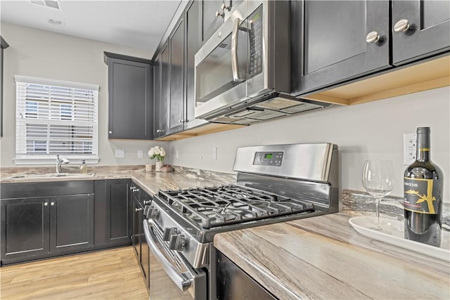 2804 Pointe View Dr, Adams Twp, PA 16046 - kitchen with appliances with stainless steel finishes, light wood-style floors, light stone counters, and dark cabinetry