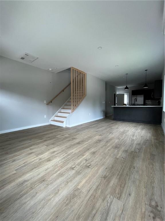 843 Ledlie St, Hill District, PA 15219 - unfurnished living room featuring wood finished floors and stairs