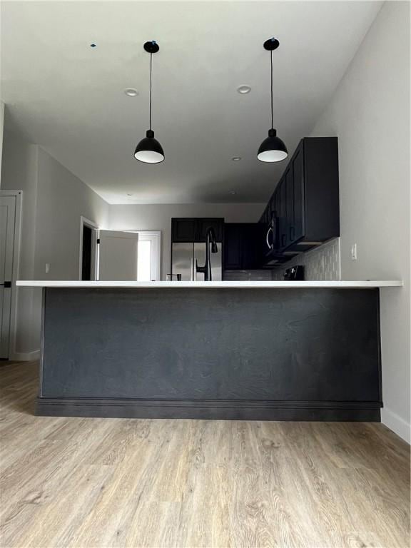 843 Ledlie St, Hill District, PA 15219 - kitchen with refrigerator, light wood-type flooring, dark cabinetry, and decorative light fixtures