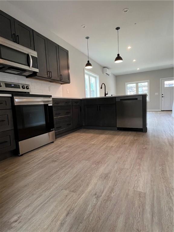 843 Ledlie St, Hill District, PA 15219 - kitchen featuring appliances with stainless steel finishes, light wood-style floors, a peninsula, hanging light fixtures, and recessed lighting