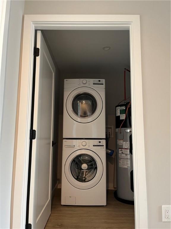 843 Ledlie St, Hill District, PA 15219 - laundry room featuring water heater, stacked washer / dryer, and wood finished floors