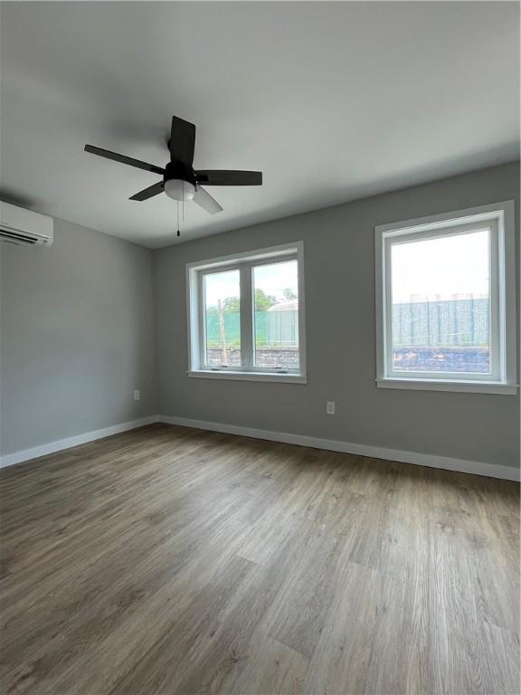 843 Ledlie St, Hill District, PA 15219 - spare room featuring a wall unit AC, wood finished floors, and ceiling fan