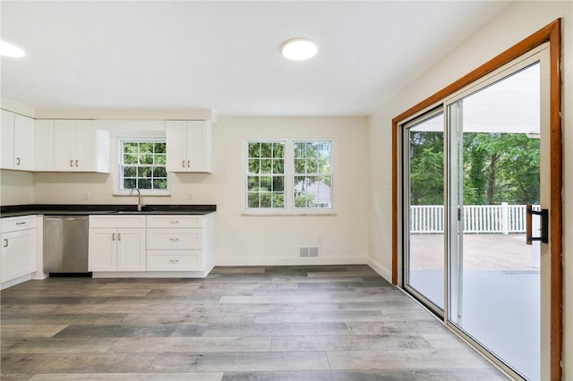 4421 Logan Ferry Rd, Murrysville, PA 15668 - kitchen with dishwasher, light wood finished floors, dark countertops, and white cabinets