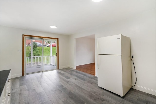 4421 Logan Ferry Rd, Murrysville, PA 15668 - kitchen with freestanding refrigerator, wood finished floors, white cabinetry, and dark countertops