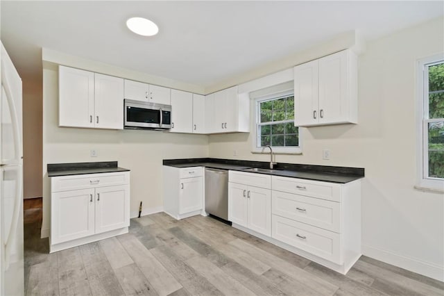 4421 Logan Ferry Rd, Murrysville, PA 15668 - kitchen with appliances with stainless steel finishes, light wood-style floors, healthy amount of natural light, and white cabinets