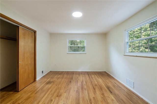 4421 Logan Ferry Rd, Murrysville, PA 15668 - unfurnished bedroom featuring multiple windows, light wood-style flooring, and a closet