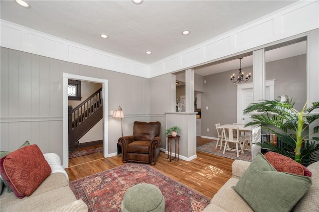 1155 French St, Sharon, PA 16146 - living area featuring wood finished floors, a chandelier, a decorative wall, recessed lighting, and stairway