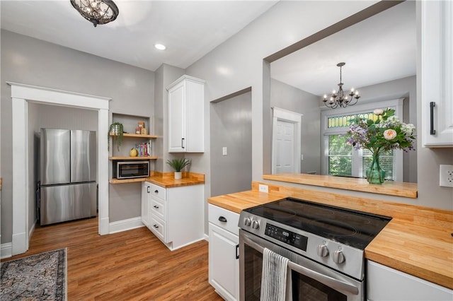 1155 French St, Sharon, PA 16146 - kitchen featuring wooden counters, stainless steel appliances, wood finished floors, a chandelier, and white cabinets