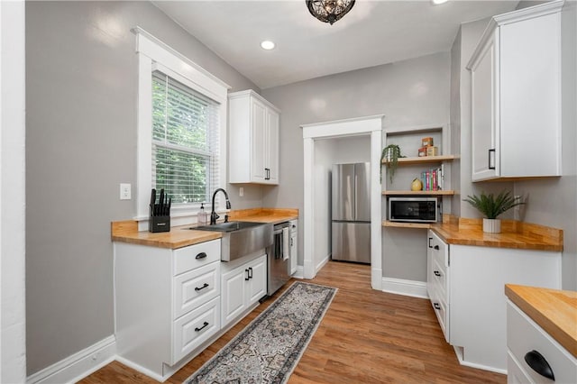 1155 French St, Sharon, PA 16146 - kitchen featuring butcher block counters, appliances with stainless steel finishes, light wood-type flooring, white cabinetry, and recessed lighting