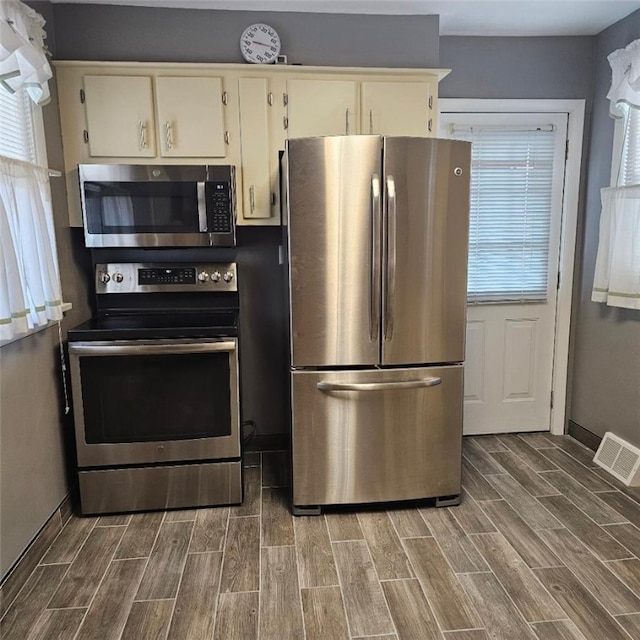 405 Penn Ave, New Brighton, PA 15061 - kitchen featuring stainless steel appliances, dark wood-style flooring, and cream cabinetry