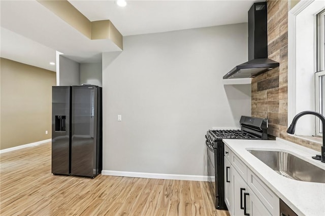 515 Peebles St, Wilkinsburg, PA 15221 - kitchen featuring refrigerator with ice dispenser, range with gas stovetop, wall chimney exhaust hood, light wood-style floors, and white cabinetry