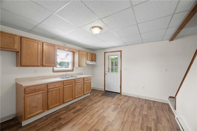 26-28 Clopper St, Sewickley Twp, PA 15637 - kitchen with light wood-type flooring, a baseboard radiator, light countertops, and a paneled ceiling