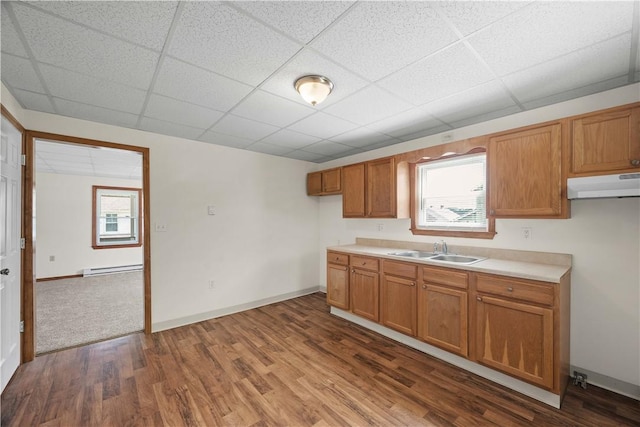 26-28 Clopper St, Sewickley Twp, PA 15637 - kitchen featuring brown cabinets, a drop ceiling, dark wood-type flooring, light countertops, and under cabinet range hood