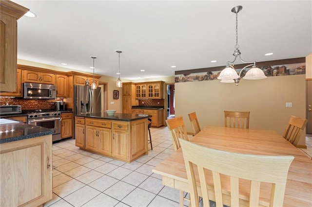94 Troutman Rd, Pa, PA 16148 - kitchen featuring stainless steel appliances, dark countertops, tasteful backsplash, light tile patterned floors, and a center island