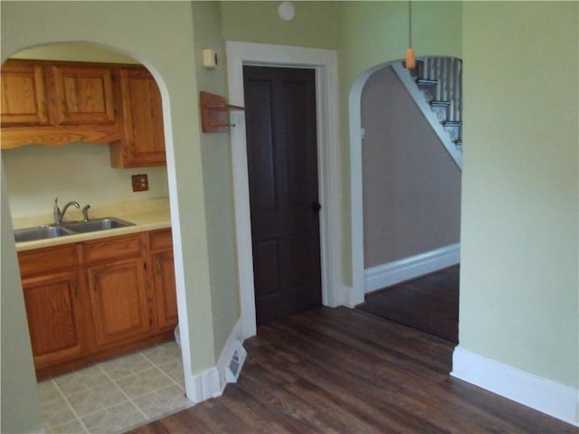 129-131 4th Ave, Scottdale, PA 15683 - kitchen with arched walkways, brown cabinets, and light wood-style floors