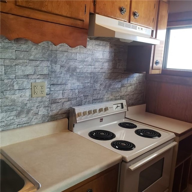 129-131 4th Ave, Scottdale, PA 15683 - kitchen with white range with electric cooktop, under cabinet range hood, light countertops, and brown cabinets
