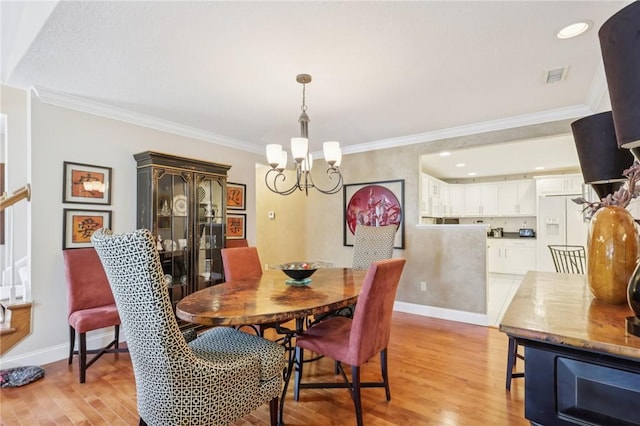 5111 Hemlock, Murrysville, PA 15668 - dining space with a chandelier, light wood finished floors, ornamental molding, stairs, and recessed lighting