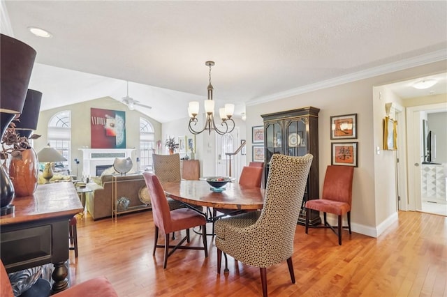 5111 Hemlock, Murrysville, PA 15668 - dining space featuring a chandelier, a ceiling fan, light wood-type flooring, a fireplace, and lofted ceiling