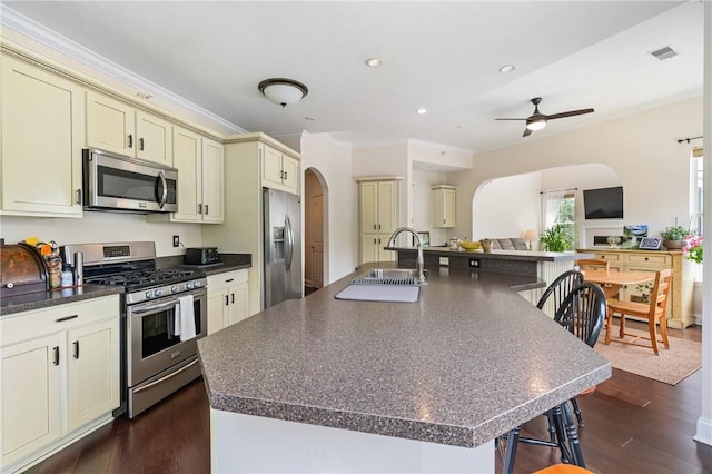 222 Adams Pointe Blvd Unit 1, Adams Twp, PA 16046 - kitchen with appliances with stainless steel finishes, cream cabinetry, arched walkways, dark countertops, and ornamental molding