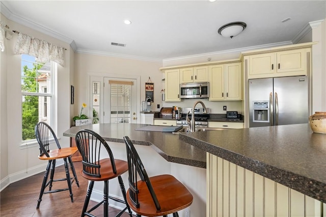 222 Adams Pointe Blvd Unit 1, Adams Twp, PA 16046 - kitchen with appliances with stainless steel finishes, cream cabinetry, healthy amount of natural light, ornamental molding, and dark countertops