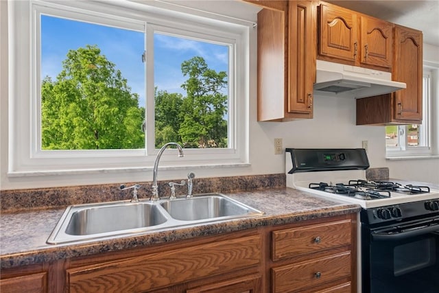 991 Diane Dr N, Versailles, PA 15137 - kitchen with black range with gas stovetop, under cabinet range hood, brown cabinetry, and dark countertops