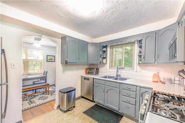 2688 Summit St, Bethel Park, PA 15102 - kitchen with stainless steel appliances, open shelves, light countertops, a textured ceiling, and arched walkways