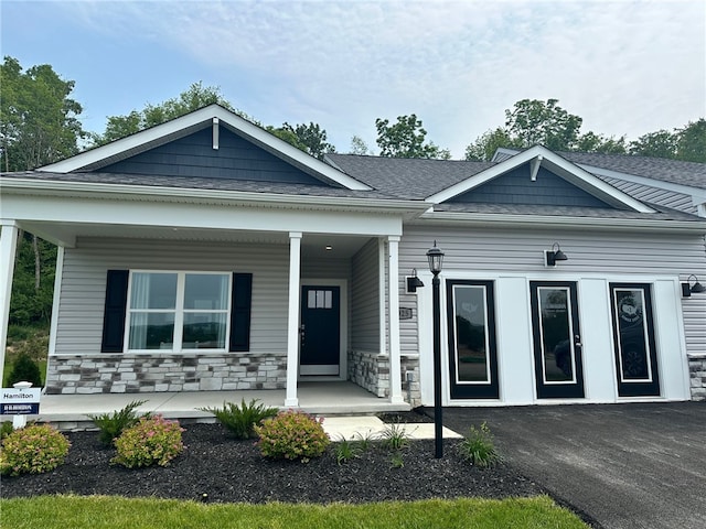 3049 Audrey Dr, Hempfield Twp, PA 15601 - view of front of house with covered porch, stone siding, and roof with shingles