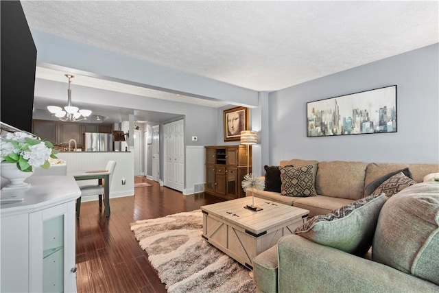 251 Commons Dr, Oakmont, PA 15139 - living area with a chandelier, dark wood-type flooring, and a textured ceiling