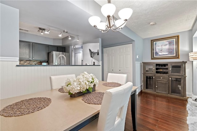 251 Commons Dr, Oakmont, PA 15139 - dining area featuring a chandelier, dark wood-type flooring, a wainscoted wall, and a textured ceiling
